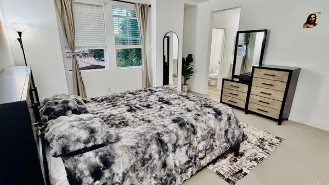 a bed sitting in a bedroom next to a window