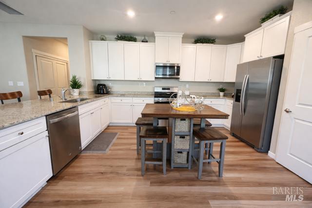 2250 Lavender Place Rio Vista, CA 94571 - Photo 3 of 13 a kitchen with stainless steel appliances a stove a sink a refrigerator white cabinets and wooden floor