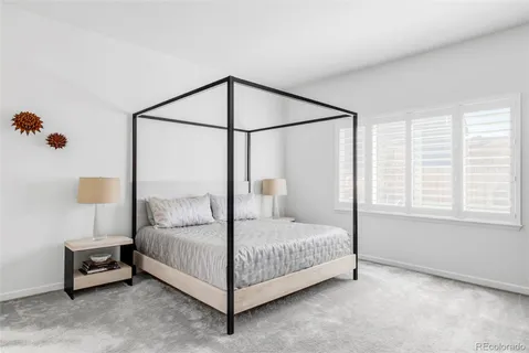 a bedroom with a bed table and a window