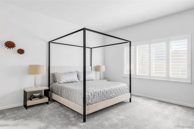 a bedroom with a bed table and a window