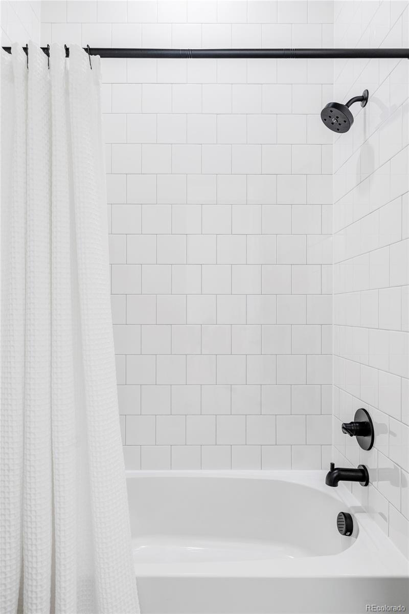 14395 Hop Clover Street Parker, CO 80134 - Photo 18 of 32 a bathroom with a shower and a bathtub