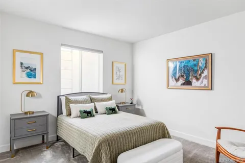 a bedroom with a bed and a painting on the wall