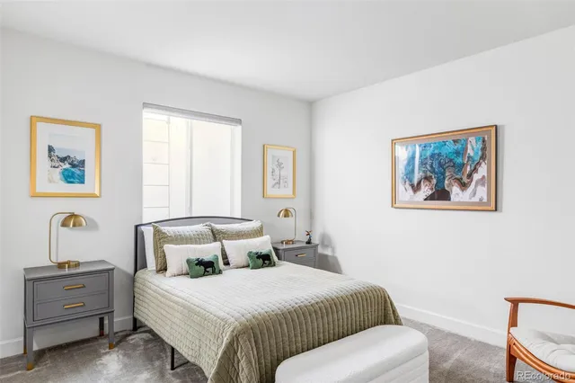 a bedroom with a bed and a painting on the wall