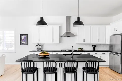 a kitchen with stainless steel appliances a table chairs and a refrigerator
