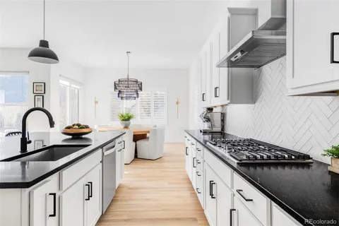a kitchen with stainless steel appliances a stove a sink dishwasher and cabinets with wooden floor
