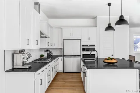 a kitchen with stainless steel appliances a stove a refrigerator and white cabinets