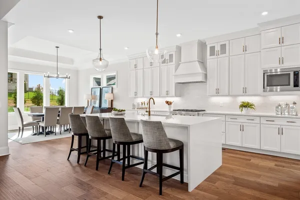 a large kitchen with kitchen island a large counter space a sink a window and stainless steel appliances