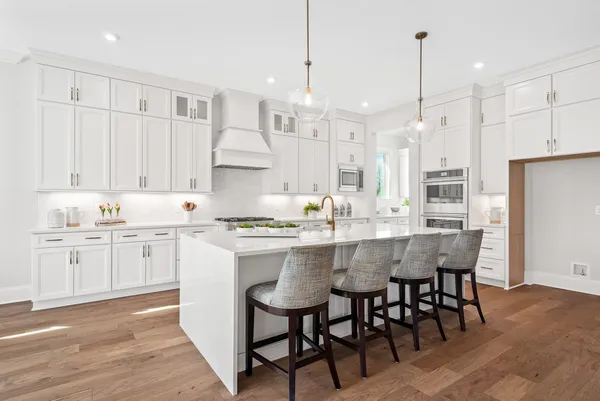 a kitchen with white cabinets and sink