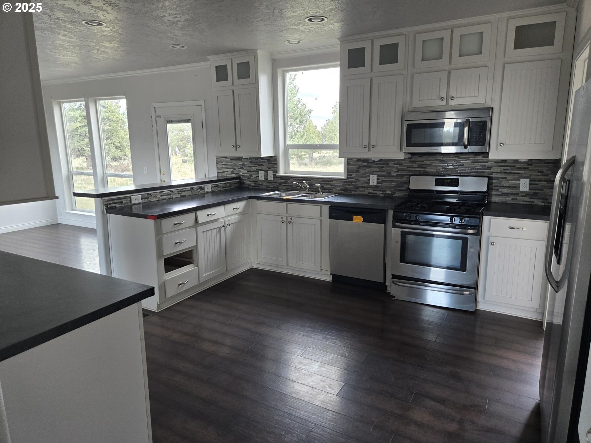 9290 Southwest 3115th Road Culver, OR 97734 - Photo 2 of 21 a kitchen with stainless steel appliances and wooden floor