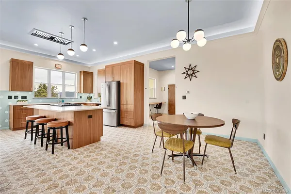 a dining room filled chandelier and kitchen view
