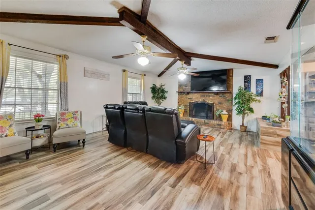 a living room with furniture a fireplace and a flat screen tv