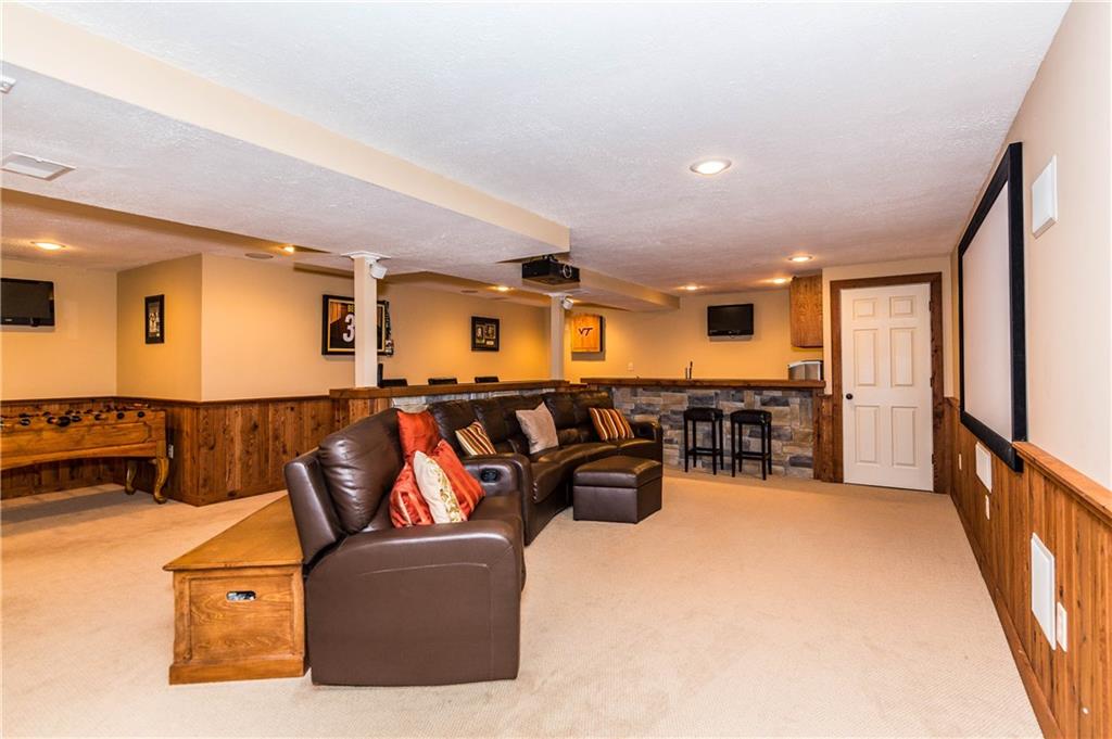 1440 Freeport Road Mars, PA 16046 - Photo 18 of 25 AMAZING LOWER LEVEL THEATRE ROOM FEATURES A LARGE PROJECTION SCREEN, BUILT IN SPEAKERS, AND A STONE ACCENTED BAR EQUIPPED WITH A WET SINK, MINI FRIG AND KEGERATOR.
