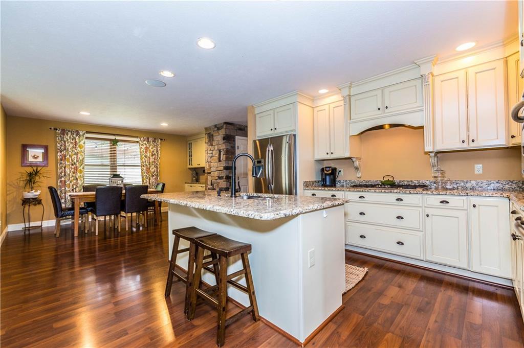 1440 Freeport Road Mars, PA 16046 - Photo 5 of 25 SPACIOUS BRIGHT KITCHEN FEATURES A CENTER ISLAND, STAINLESS STEEL APPLIANCES, GRANITE COUNTERTOPS AND A GAS COOK TOP. KITCHEN OPENS TO THE DINING ROOM FEATURING A BUILT IN BUFFET AND STONE WALL.