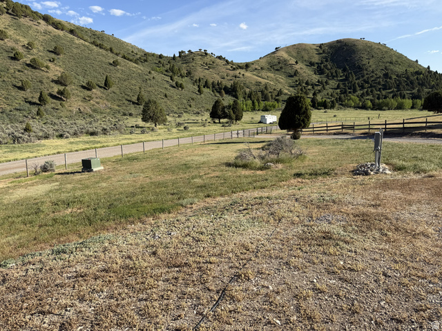 2006 Swenson Valley Road Bancroft, ID 83217 - Photo 28 of 51 Expansive open land with a gravel road, bordered by a wooden fence