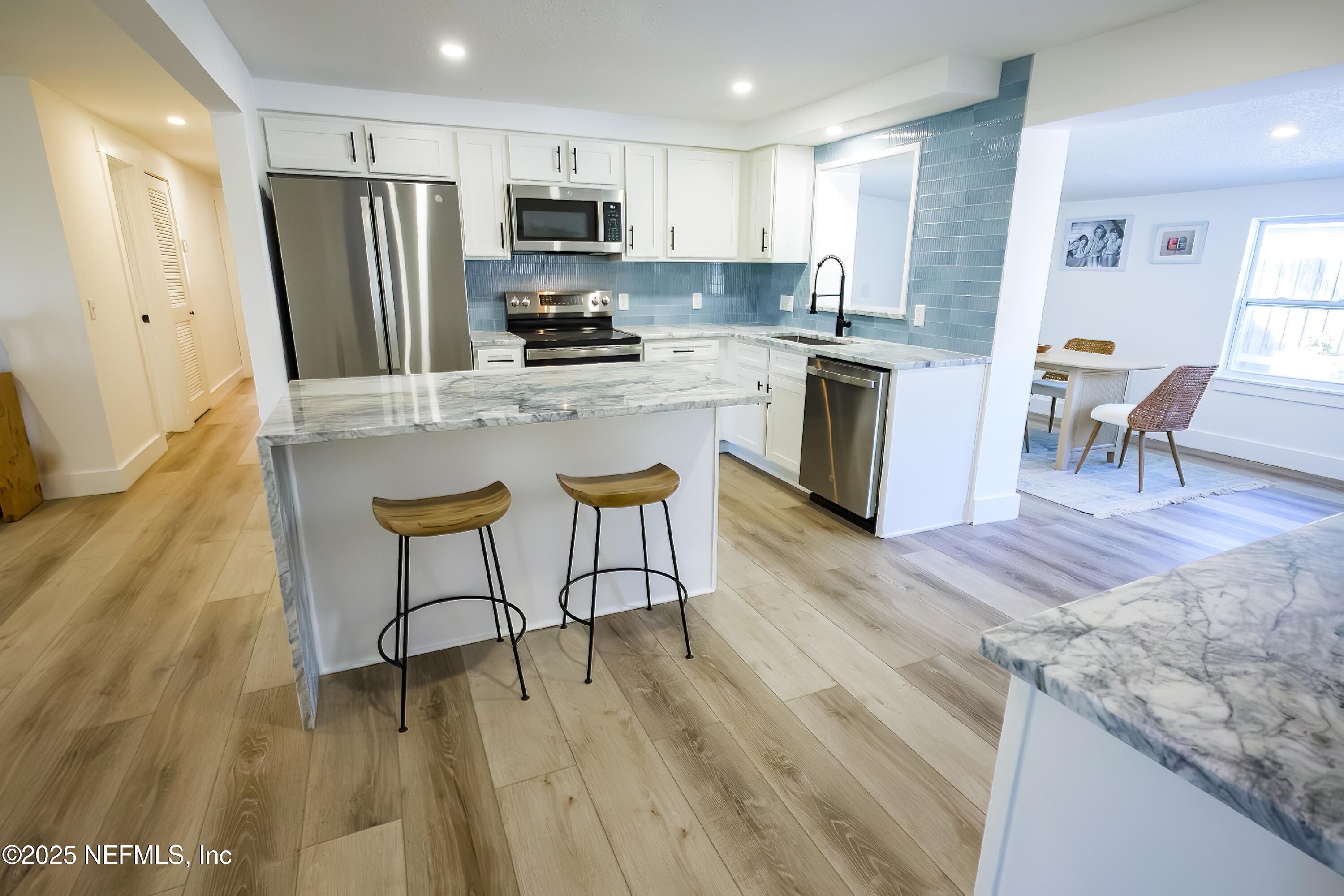 785 Triton Road Atlantic Beach, FL 32233 - Photo 8 of 46 a kitchen with stainless steel appliances granite countertop a stove a sink a refrigerator and a microwave
