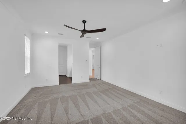 a view of a livingroom with a ceiling fan and window