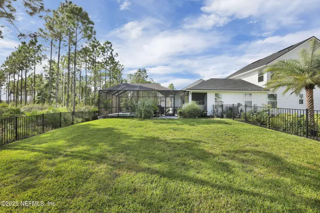 a view of a swimming pool with seating area and trees in the background