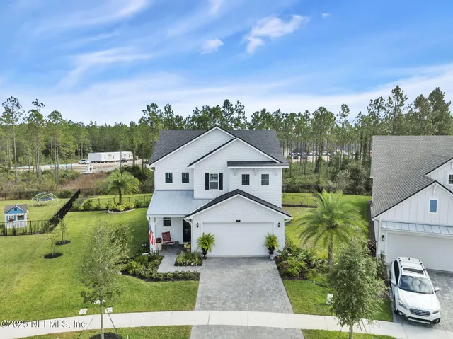 an aerial view of residential houses with outdoor space and swimming pool