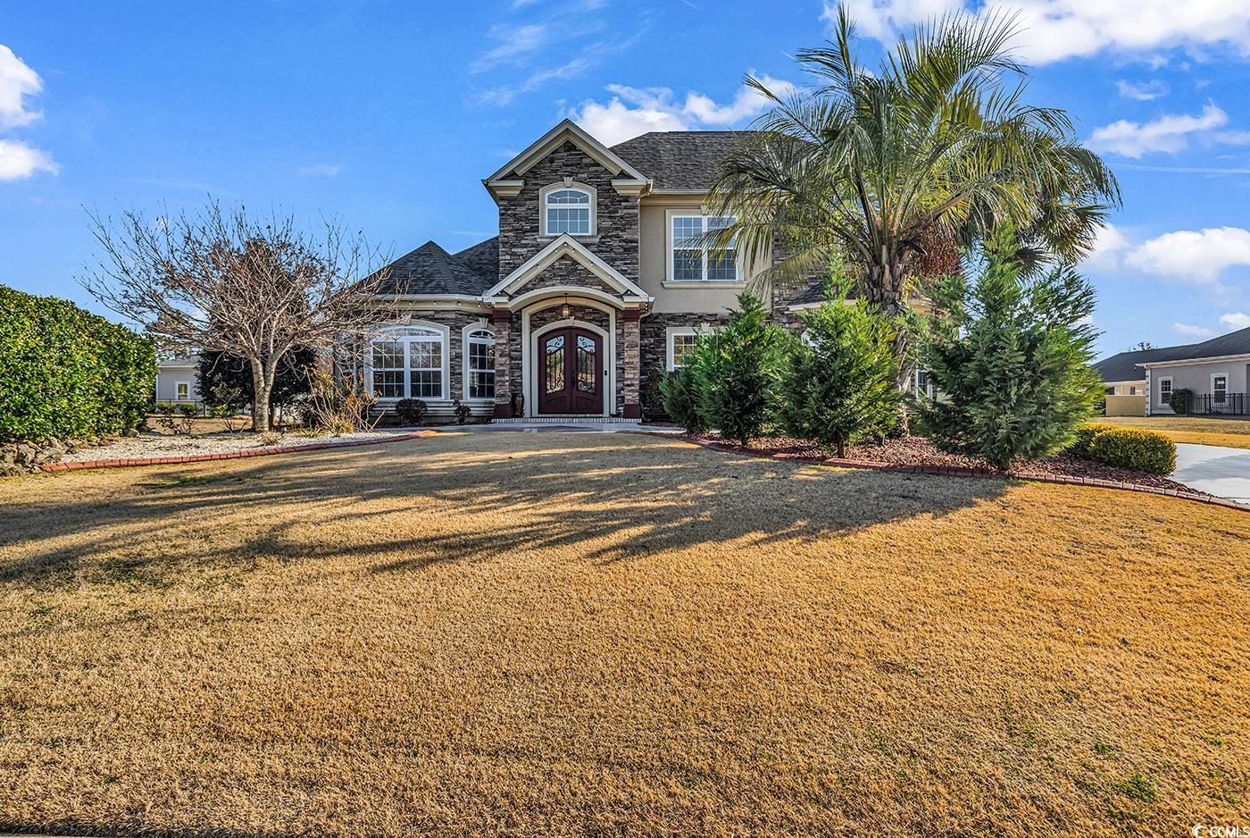 801 Bluffview Drive Myrtle Beach, SC 29579 - Photo 1 of 40 View of front of property featuring stone siding, a front lawn, stucco siding, and french doors