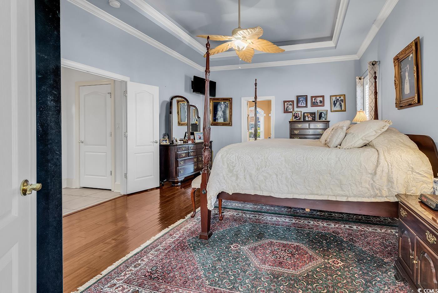 801 Bluffview Drive Myrtle Beach, SC 29579 - Photo 13 of 40 Bedroom with a ceiling fan, wood finished floors, a raised ceiling, and crown molding