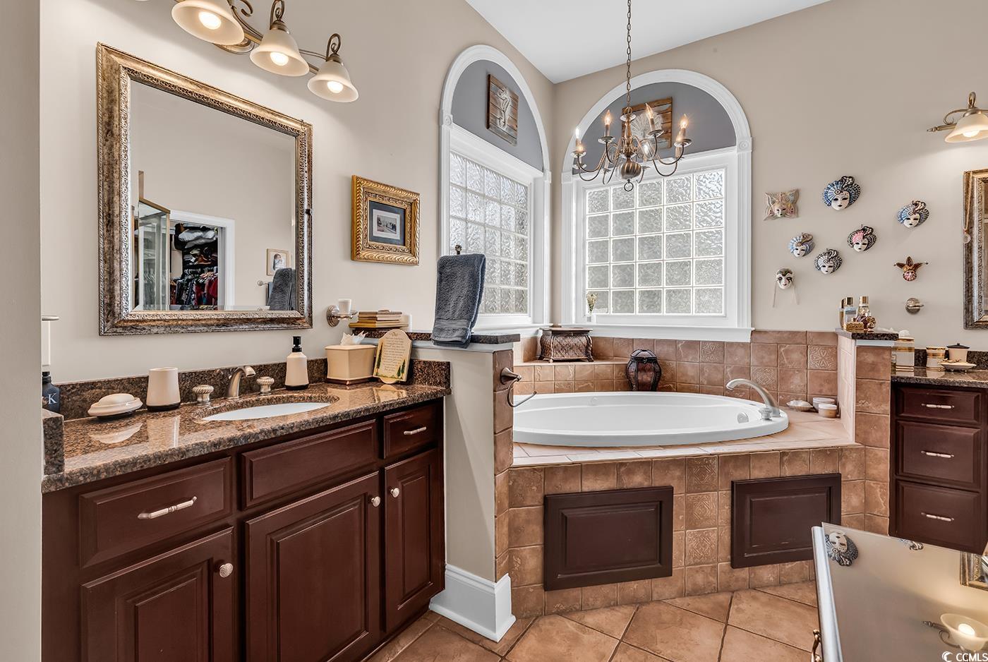 801 Bluffview Drive Myrtle Beach, SC 29579 - Photo 14 of 40 Full bath featuring a garden tub, light tile patterned floors, vanity, and a chandelier