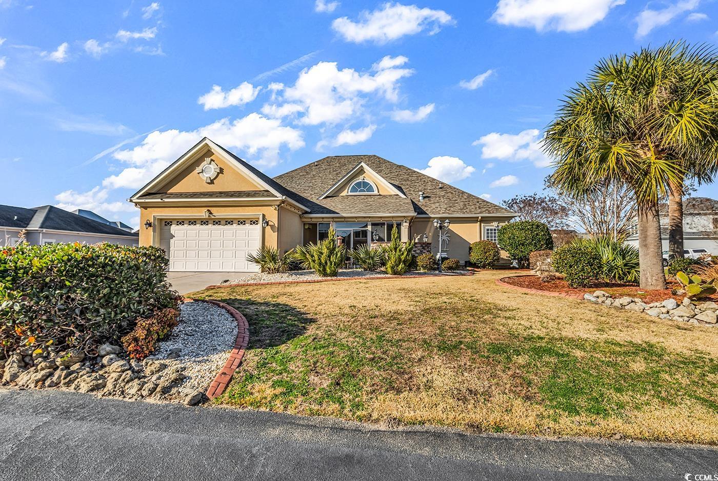 801 Bluffview Drive Myrtle Beach, SC 29579 - Photo 2 of 40 View of front of home featuring stucco siding, driveway, a front lawn, and a garage