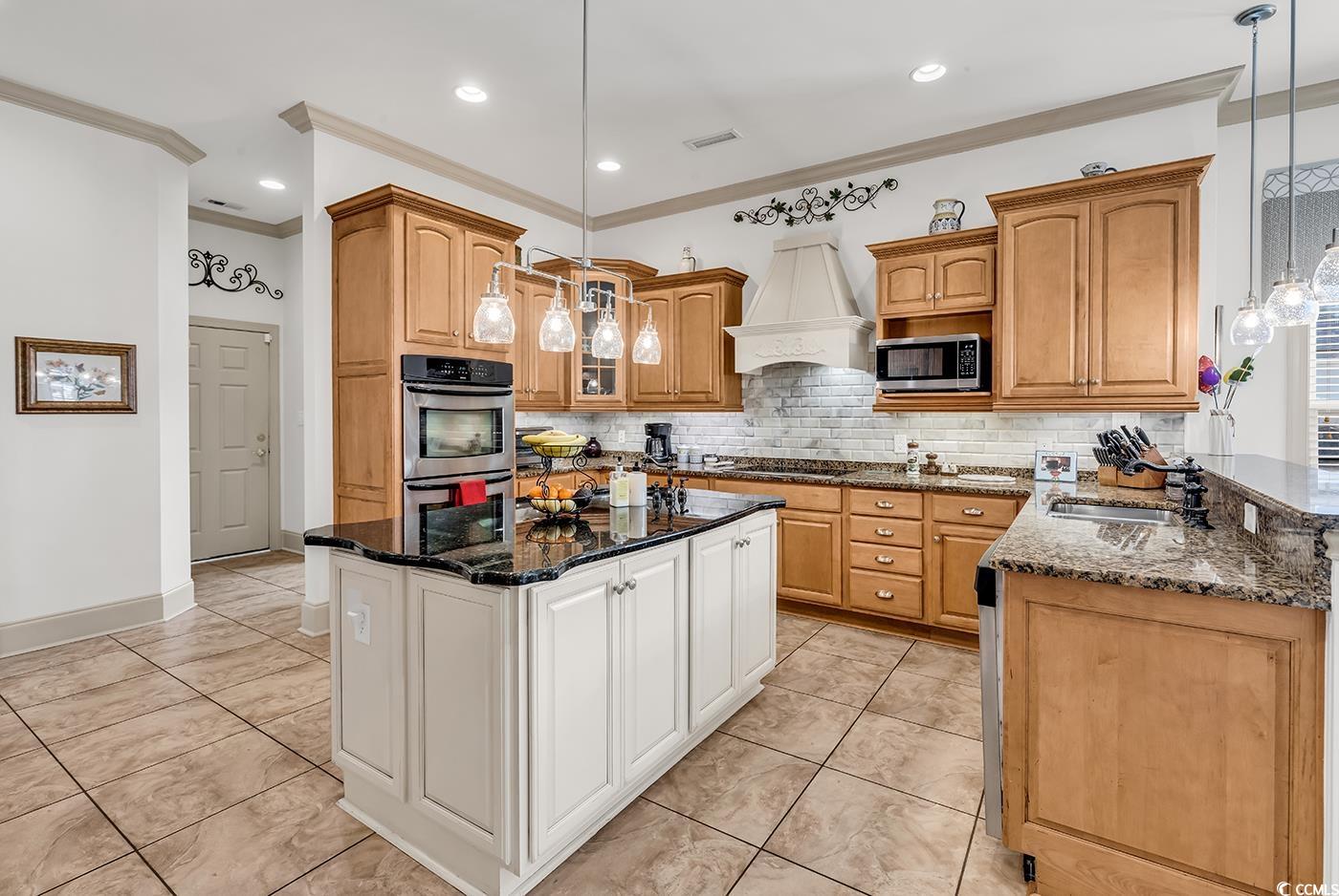 801 Bluffview Drive Myrtle Beach, SC 29579 - Photo 21 of 40 Kitchen featuring white cabinetry, ornamental molding, decorative light fixtures, dark stone countertops, and appliances with stainless steel finishes
