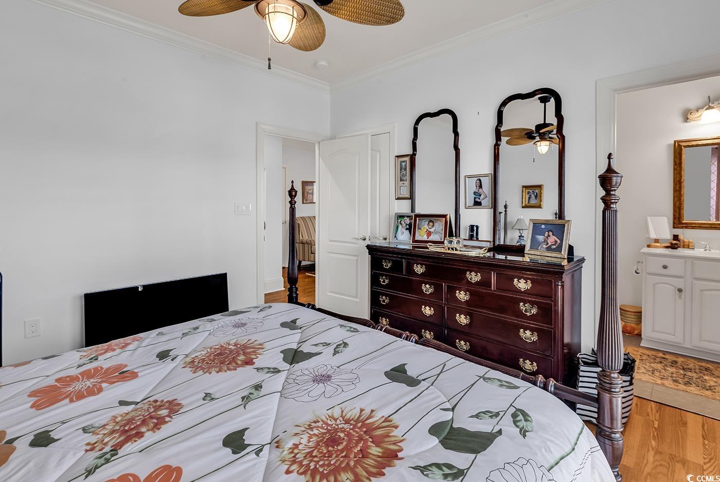 801 Bluffview Drive Myrtle Beach, SC 29579 - Photo 26 of 40 Bedroom featuring light wood-style flooring, ornamental molding, ceiling fan, and ensuite bathroom