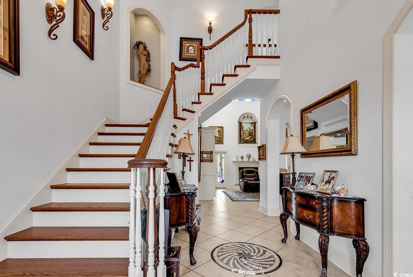 801 Bluffview Drive Myrtle Beach, SC 29579 - Photo 3 of 40 Staircase featuring a high ceiling, arched walkways, and tile patterned flooring
