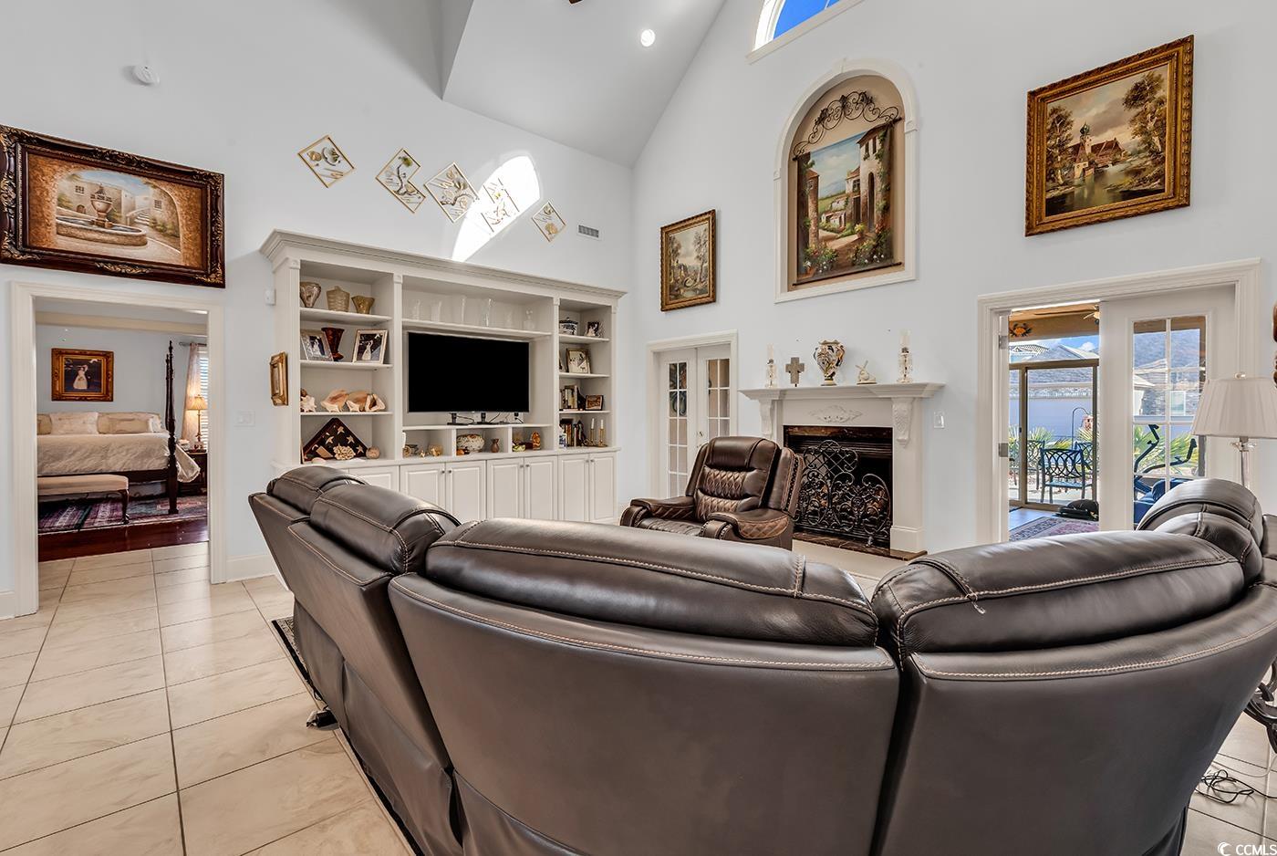 801 Bluffview Drive Myrtle Beach, SC 29579 - Photo 8 of 40 Living area featuring high vaulted ceiling, light tile patterned floors, a fireplace, and a skylight