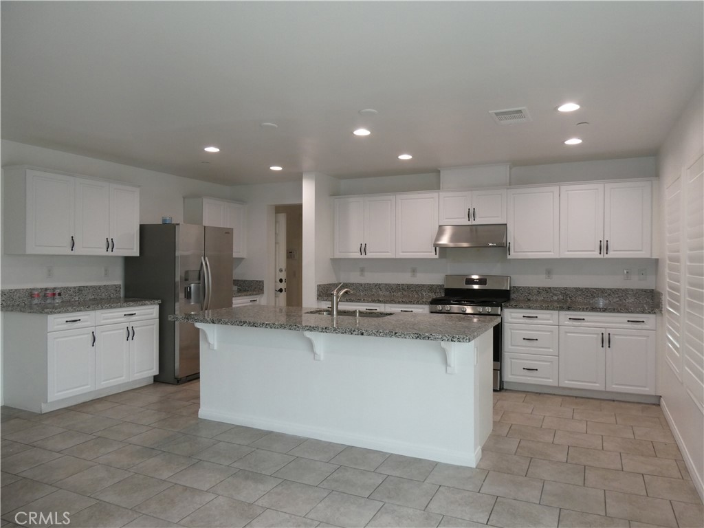 7613 Steamboat Street Riverside, CA 92507 - Photo 2 of 17 a kitchen with stainless steel appliances granite countertop a stove top oven a sink and dishwasher