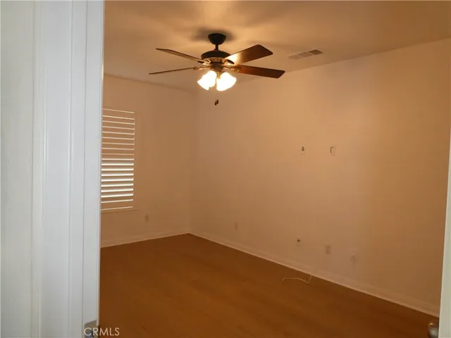 a view of a room with a ceiling fan and a window