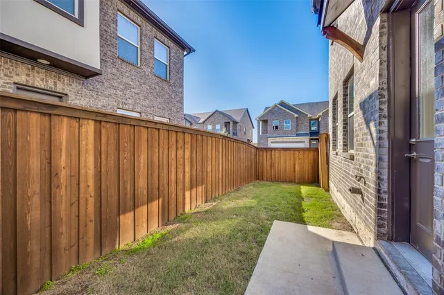 a view of a house with backyard and wooden fence