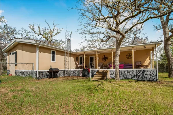 a view of a house with backyard and sitting area