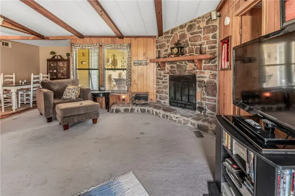 a living room with furniture a fireplace and a large window