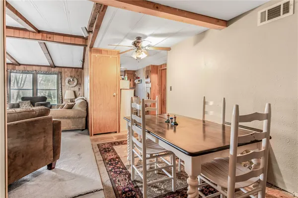 a living room with furniture a chandelier and a dining table