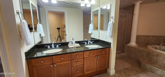 a bathroom with a granite countertop double vanity sink and mirror
