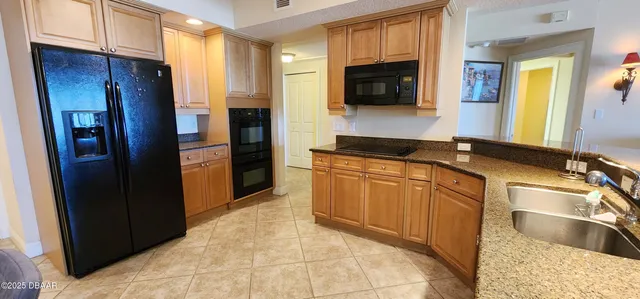 a kitchen with granite countertop a refrigerator and a sink