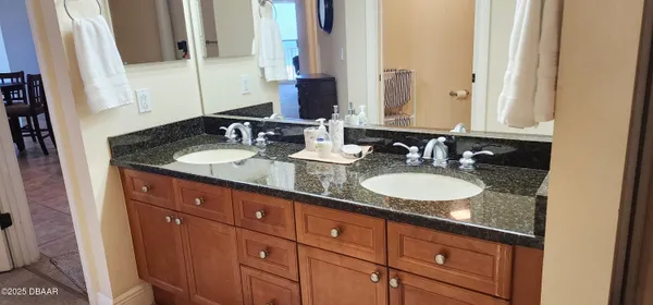 a bathroom with double vanity and a mirror