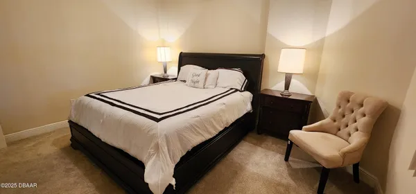 a bed sitting in a bedroom and lamp next to a window