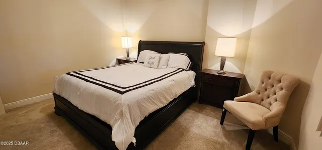 a bed sitting in a bedroom and lamp next to a window