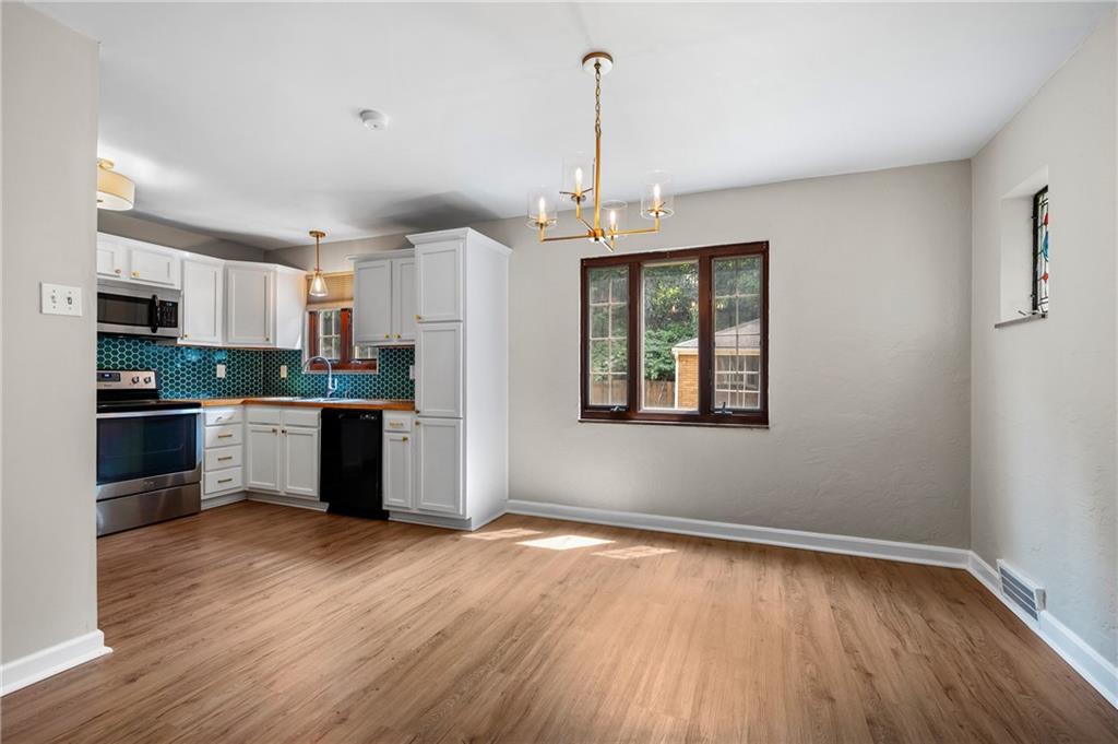 3729 Baytree Street Pittsburgh, PA 15214 - Photo 10 of 30 a kitchen with stainless steel appliances granite countertop a refrigerator a sink dishwasher a stove and white countertops with wooden floor