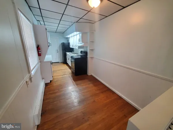 a view of a kitchen with a sink and wooden floor