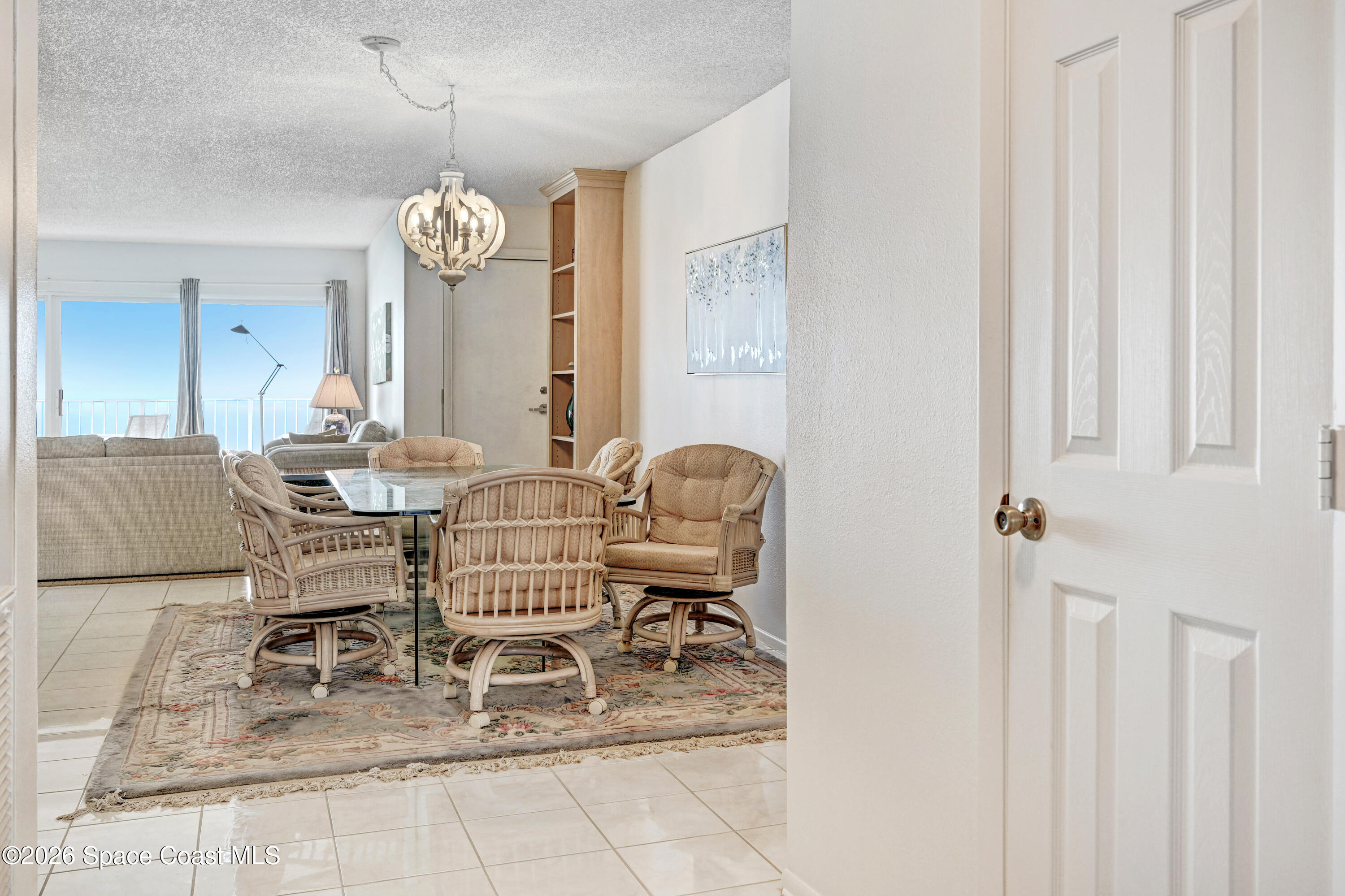 2101 Atlantic Street, Unit 533 Melbourne Beach, FL 32951 - Photo 11 of 51 a dining room with furniture and a chandelier