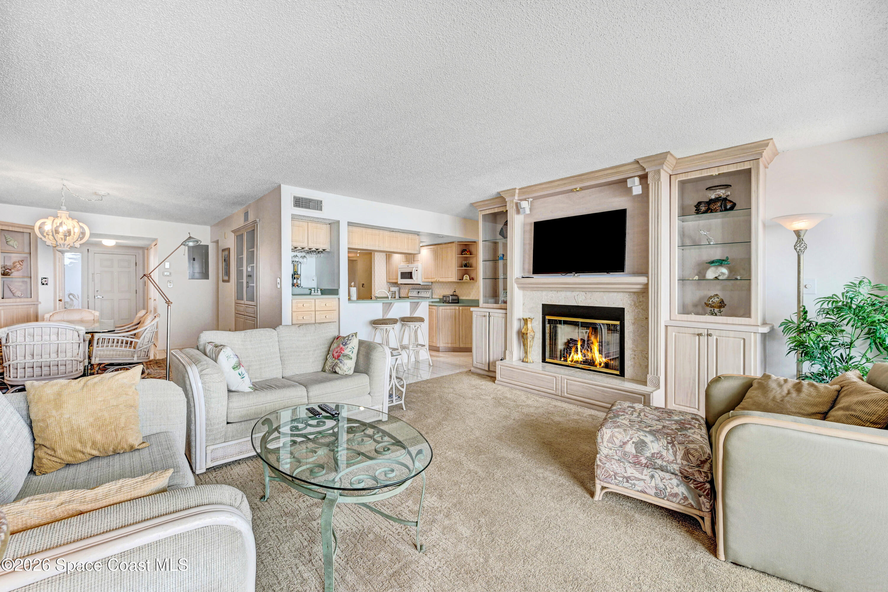 2101 Atlantic Street, Unit 533 Melbourne Beach, FL 32951 - Photo 18 of 51 a living room with furniture a fireplace and a flat screen tv