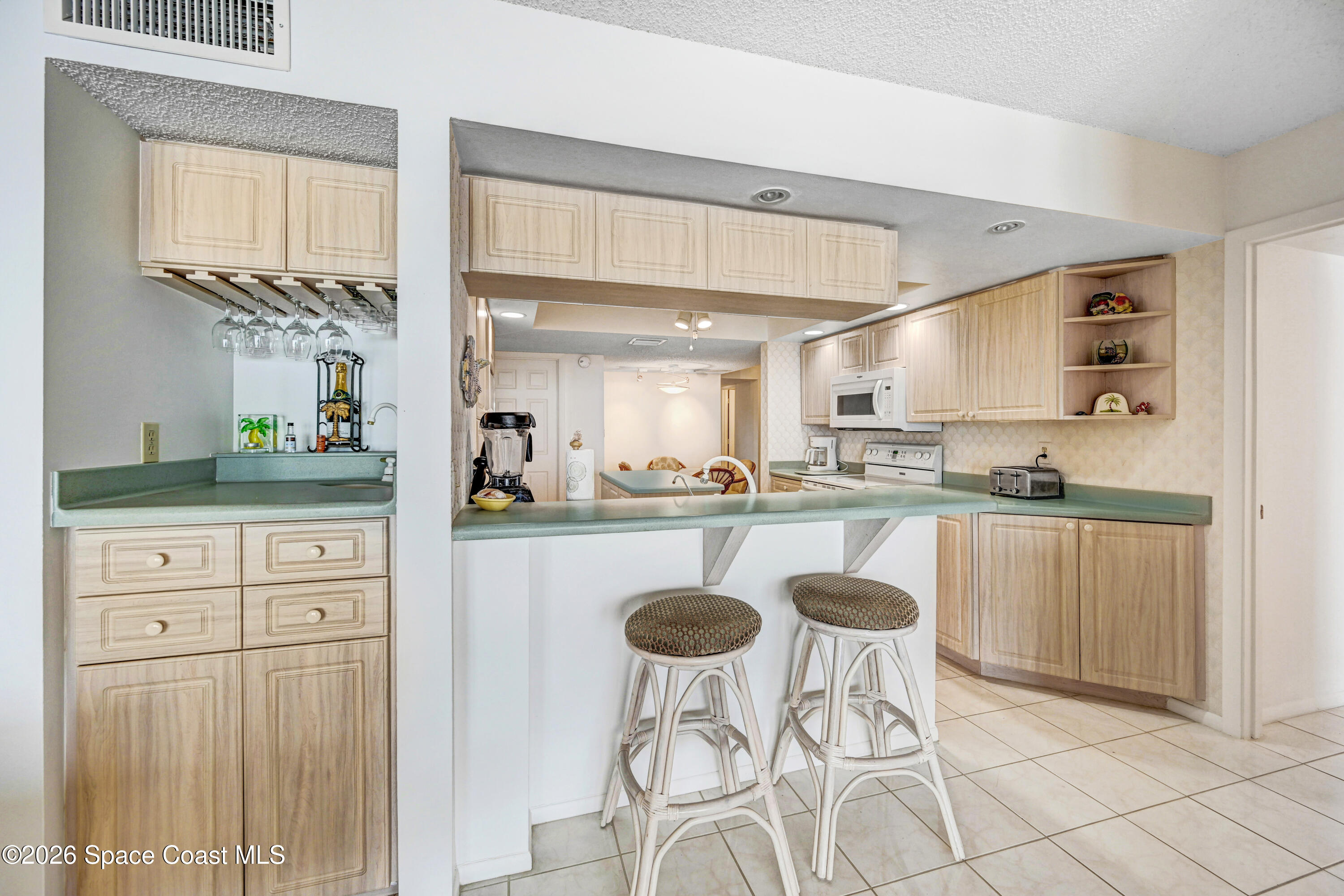 2101 Atlantic Street, Unit 533 Melbourne Beach, FL 32951 - Photo 19 of 51 a kitchen with cabinets and chairs