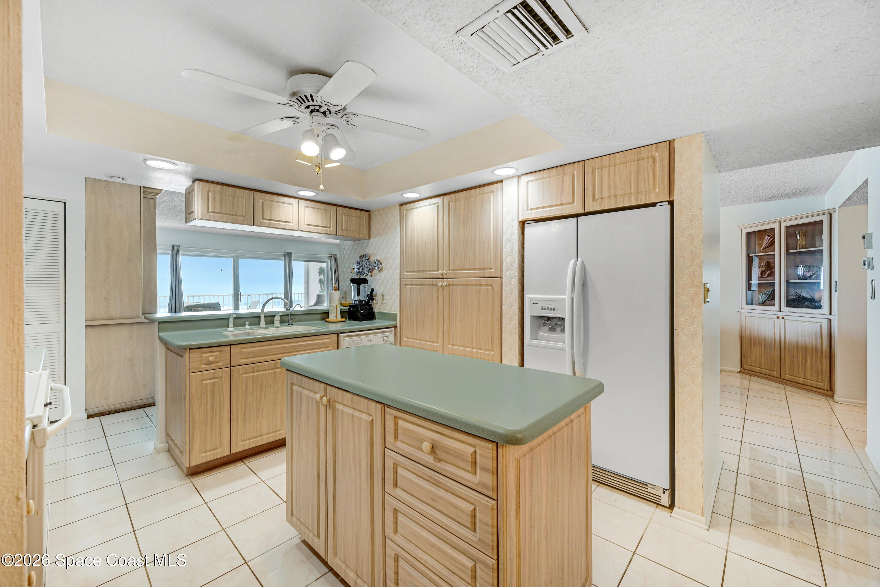 2101 Atlantic Street, Unit 533 Melbourne Beach, FL 32951 - Photo 24 of 51 a kitchen with kitchen island a counter top space appliances and cabinets