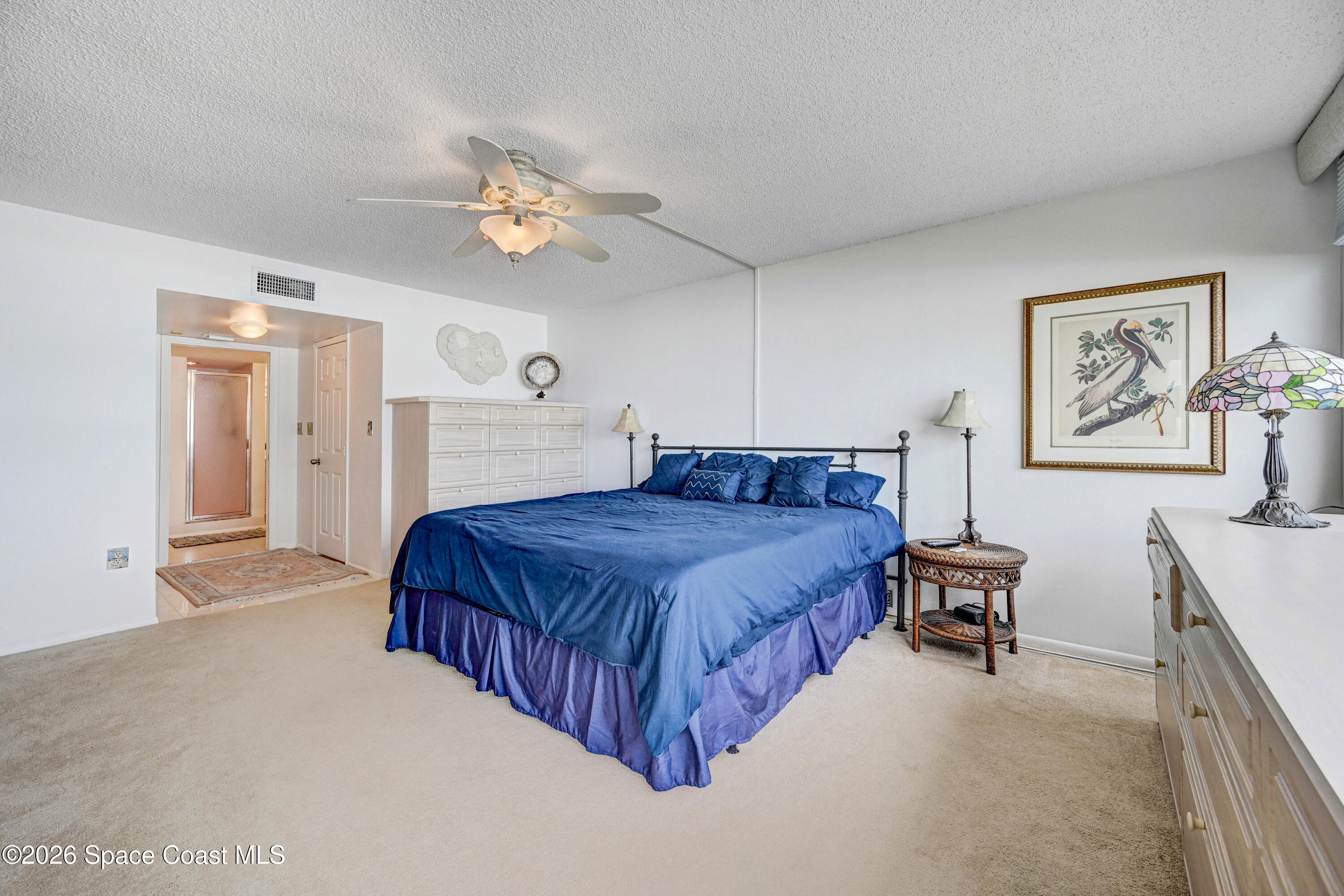 2101 Atlantic Street, Unit 533 Melbourne Beach, FL 32951 - Photo 31 of 51 a spacious bedroom with a bed and a chandelier