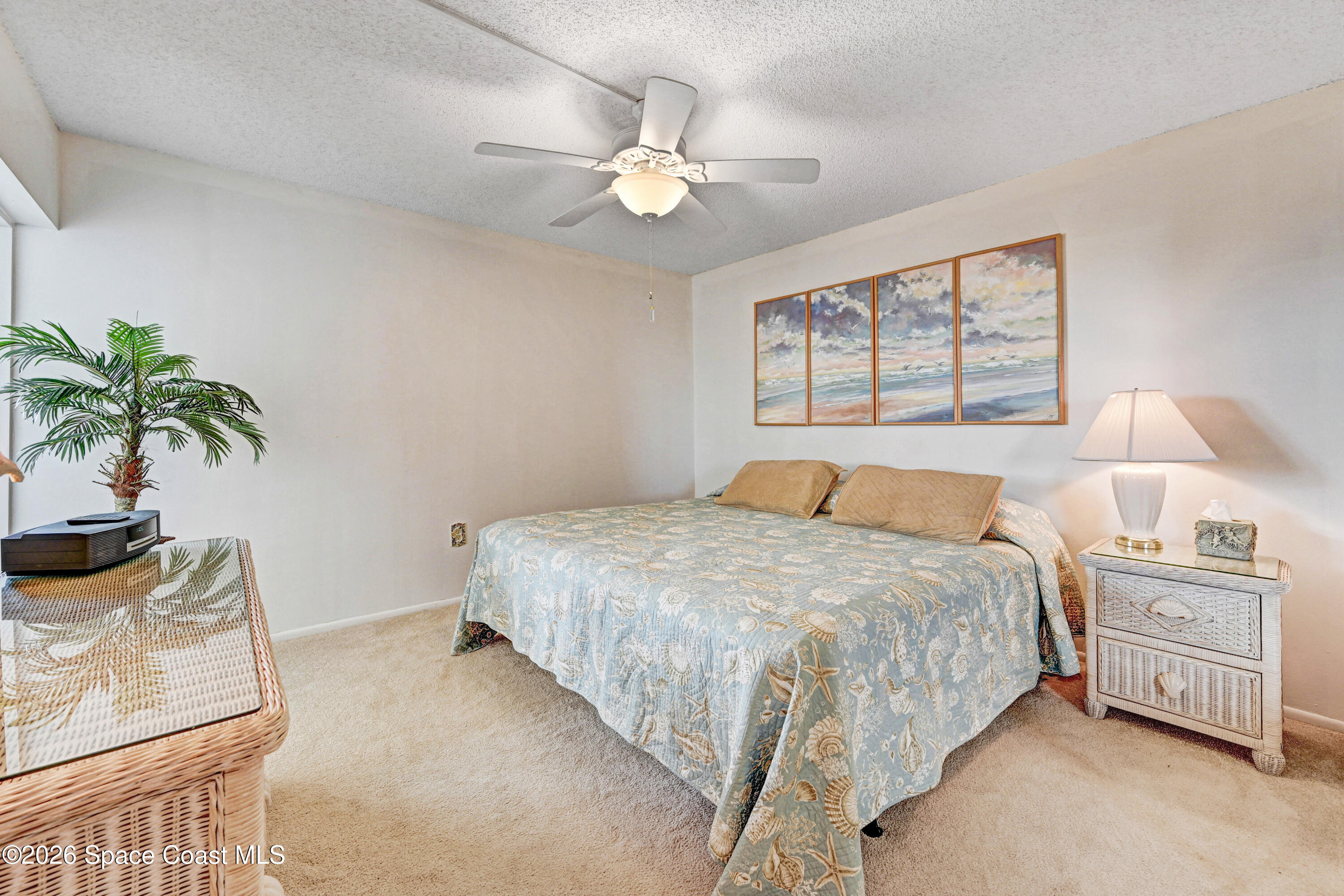 2101 Atlantic Street, Unit 533 Melbourne Beach, FL 32951 - Photo 39 of 51 a bedroom with a bed and a potted plant on the dresser