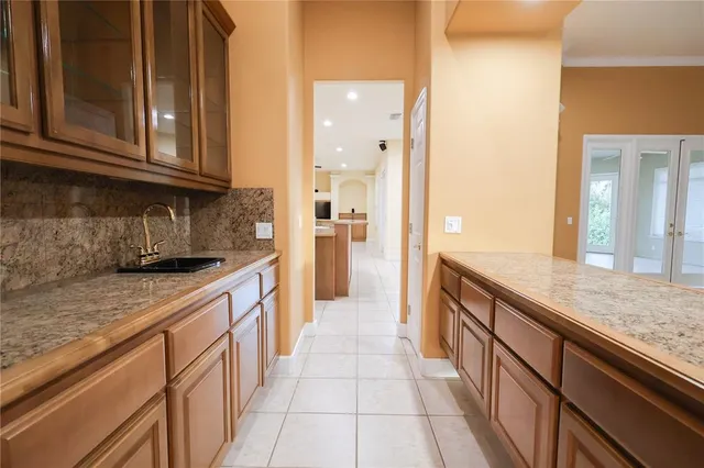 a large kitchen with granite countertop a sink and dishwasher stove a refrigerator with wooden cabinets